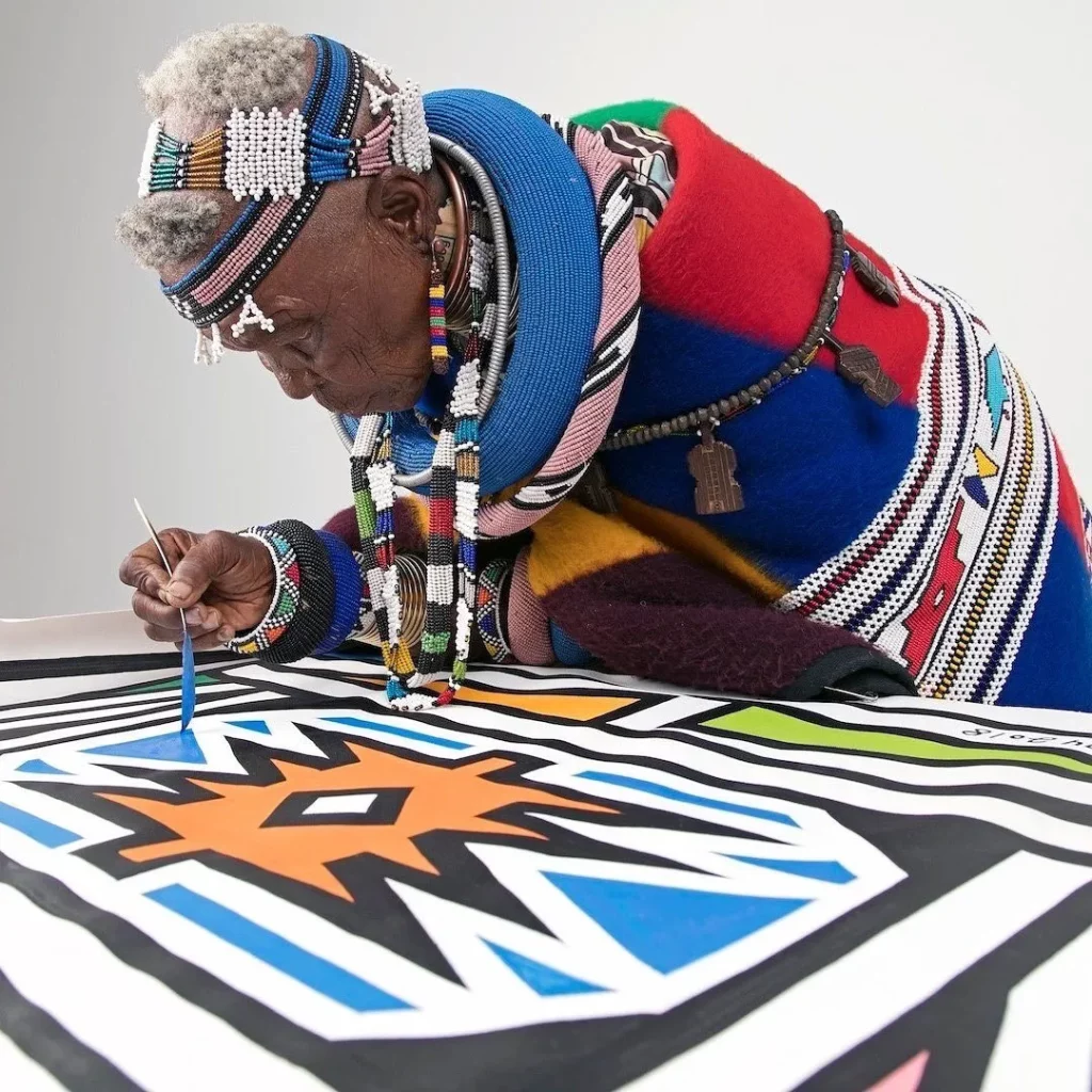 Ndebele  of South Africa and Zimbabwe woman in a rich tradition of gorgeous colorful quilts and blankets entirely hand-made