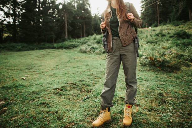 portrait of active girl in hiking pants standing in beautiful forest.